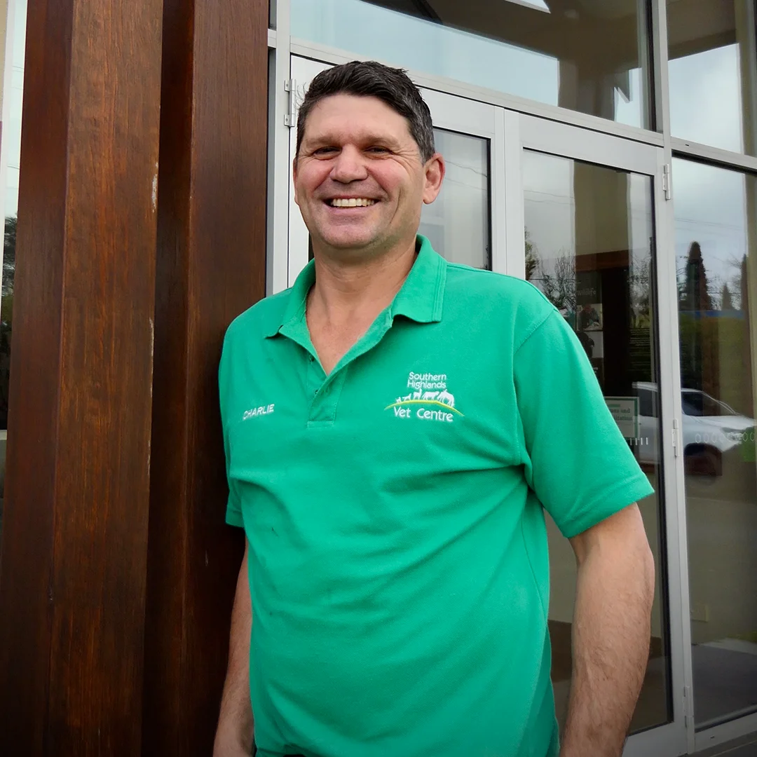 Charlie Carter, owner and veterinarian at Southern Highlands Veterinary Centre, standing outside the clinic wearing a green uniform and smiling.