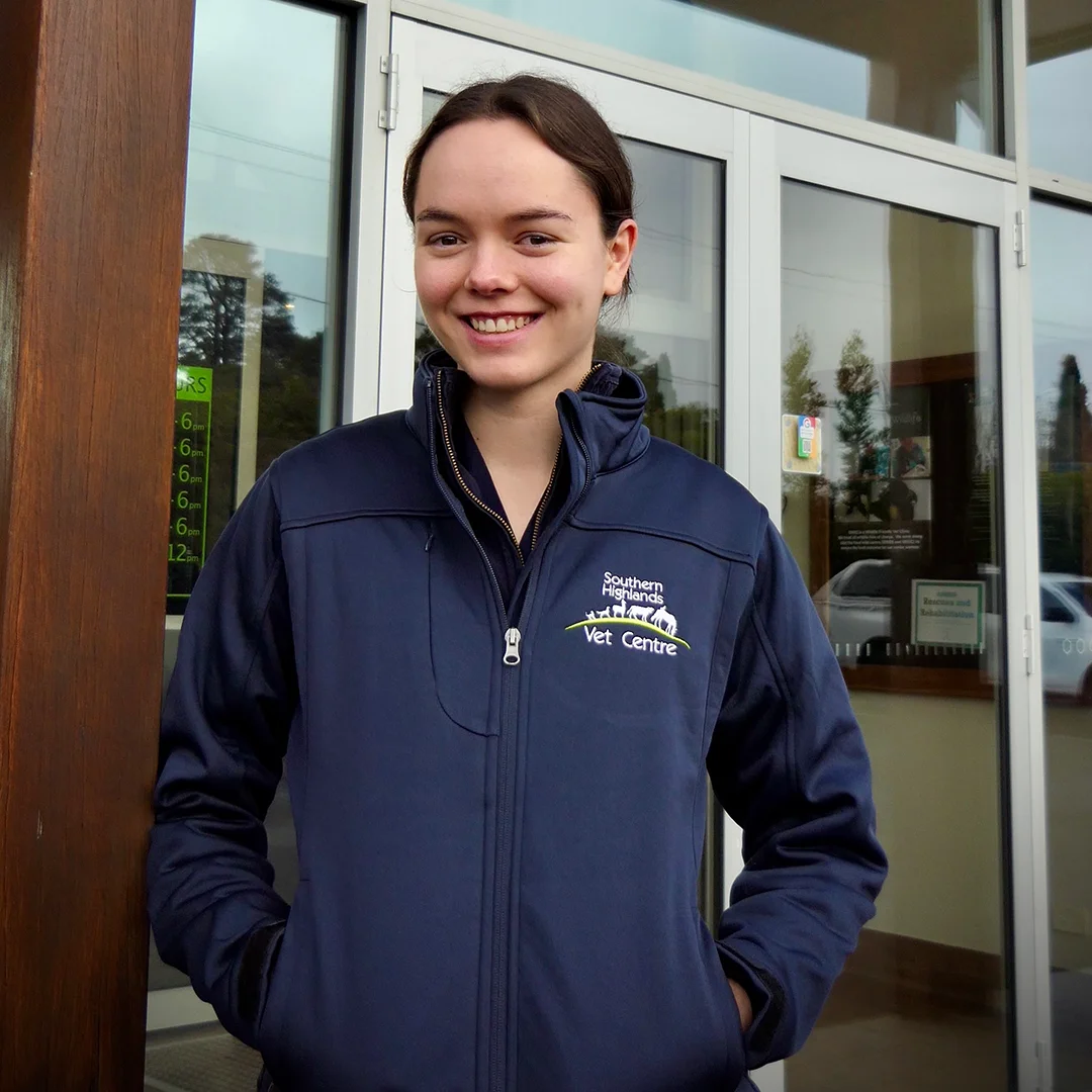 Matilda East, a veterinary team member at Southern Highlands Veterinary Centre, smiling outside the clinic wearing a branded jacket.